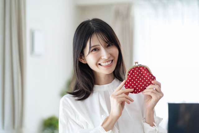 財布を掲げる女性